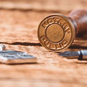 A wooden table with some keys and a stamp