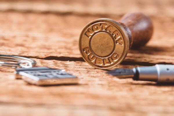 A wooden table with some keys and a stamp