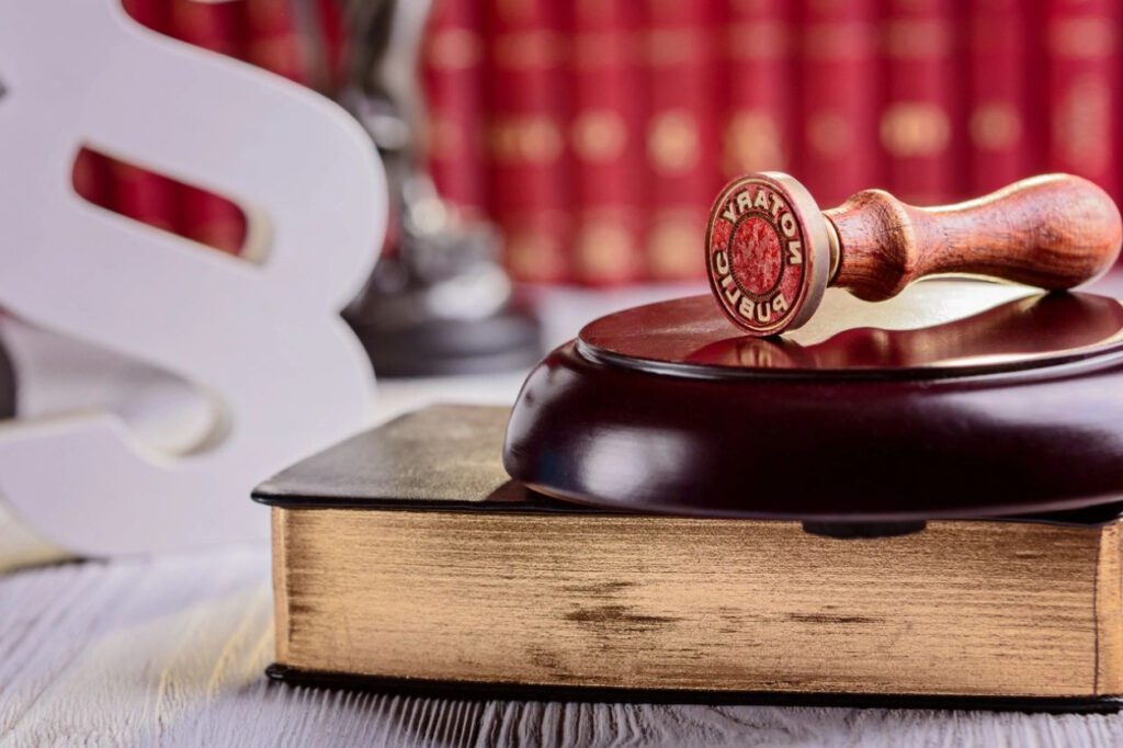 A wooden gavel sitting on top of an old book.